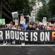 Climate activists marching with banner that reads Our House is on Fire